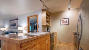 A modern kitchen with wooden cabinetry, a built-in sink, and a stainless steel refrigerator. - Teton Homestead: Modern Corner Top Unit + Hot Tub (Driggs)