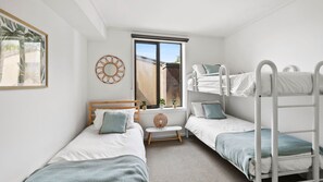 Cozy retreat with a single bed, two bunk beds, and a comfortable bench.