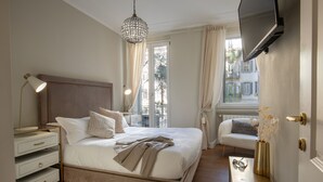 A bedroom with a bed, bedside tables, a chair, a TV, and a window with curtains. - Daplace - Corso Monforte Suites (Milan)