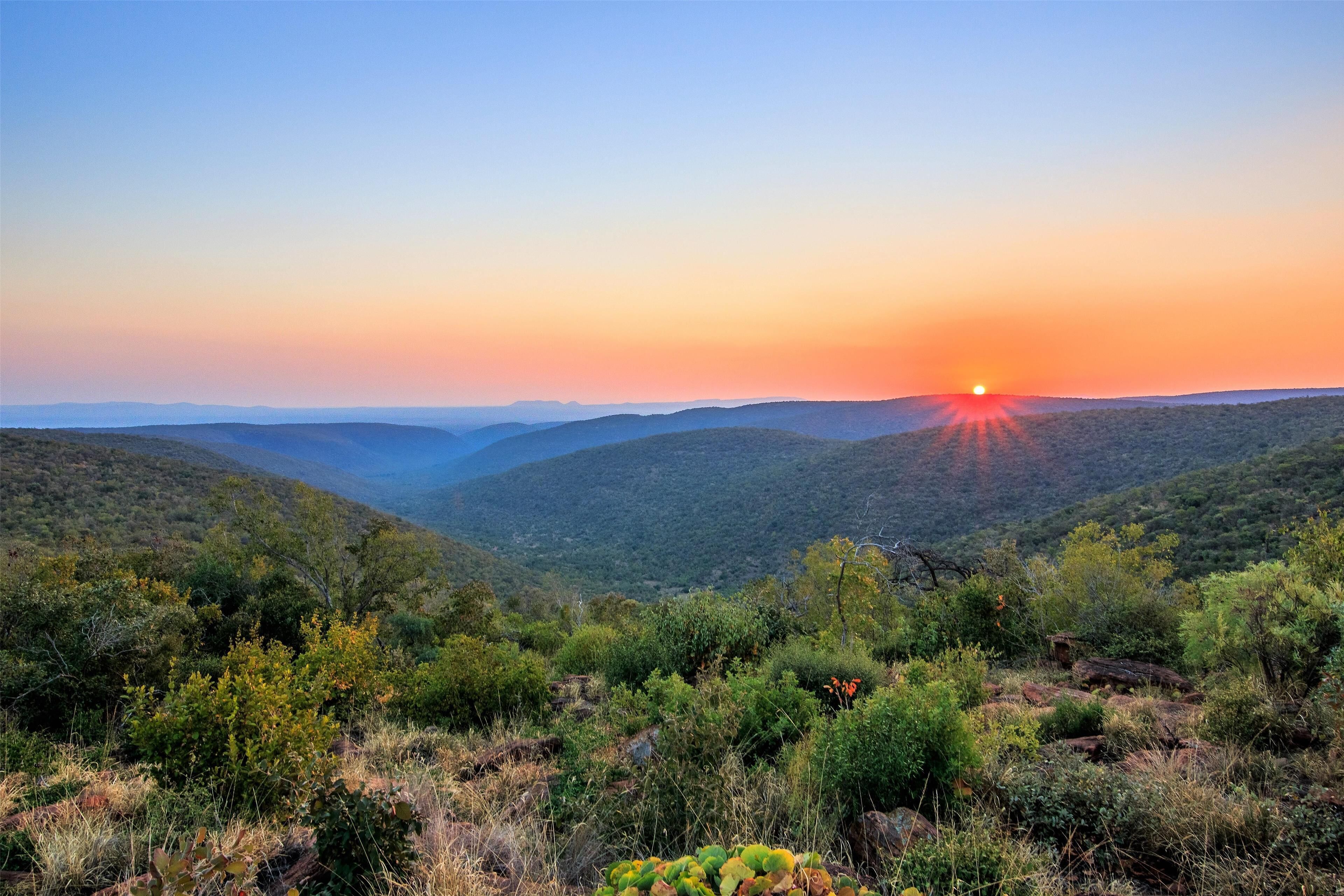 A mountainous landscape with a sunset.