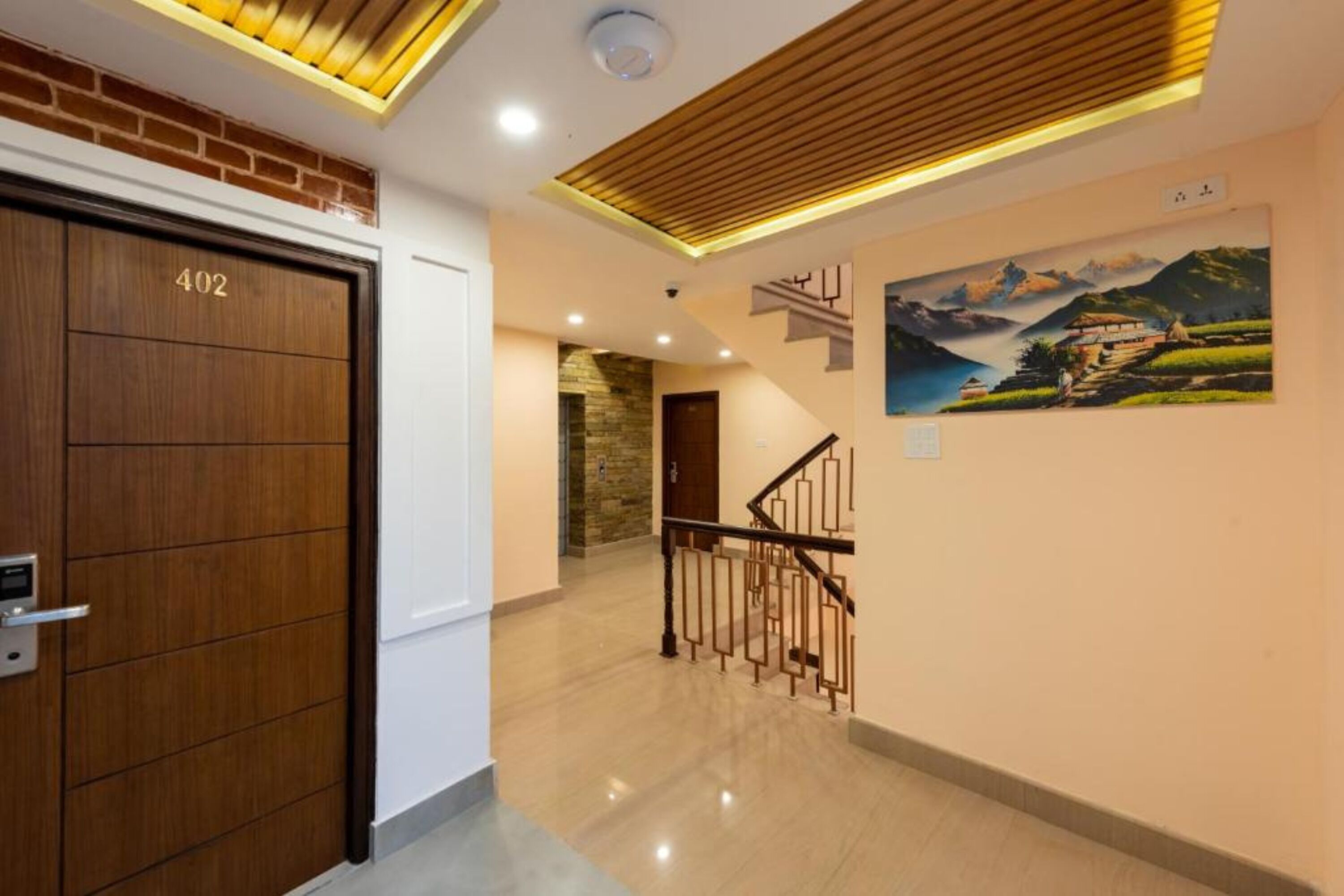 A modern interior with a wooden door labeled 402, a staircase, and a mural on the wall.