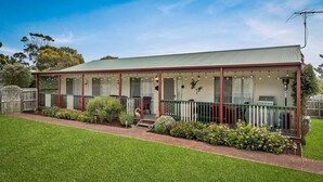 A two-story house with a covered porch, a fenced yard, and a well-maintained garden. - Cross Rhodes in Wimbledon Heights (Wimbledon Heights)