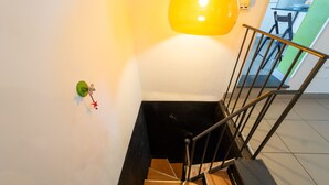 A staircase with a metal handrail and a wall-mounted light fixture. - Stylish in Spanish Quarter by Wonderful Italy (Napoli)