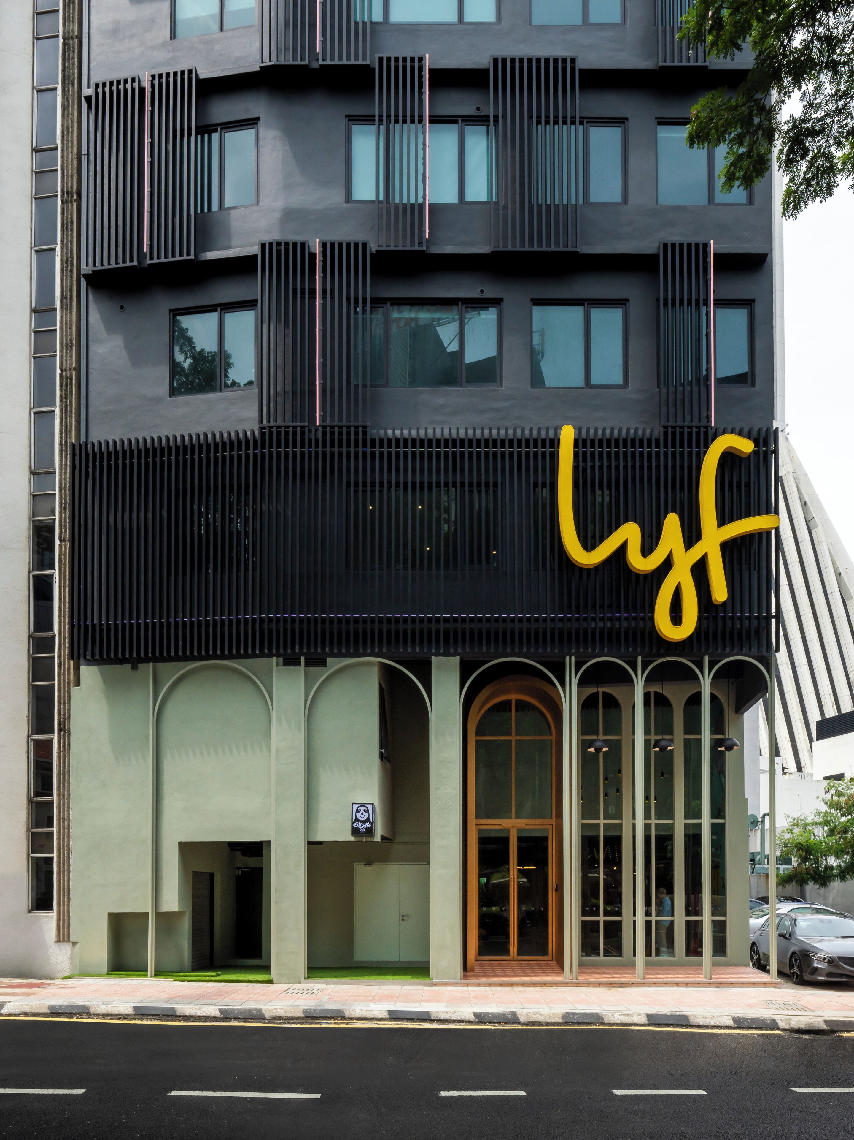 A modern building with a prominent black facade, large windows, and a yellow 'Lyf' logo.