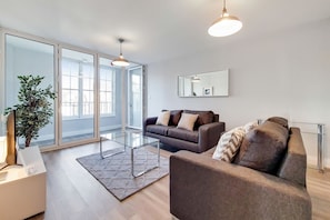 Relax in this stylish living space with a sofa, coffee table, and large mirror.