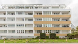 Un edificio residenziale a più piani con balconi, ampie finestre e tetto piano.