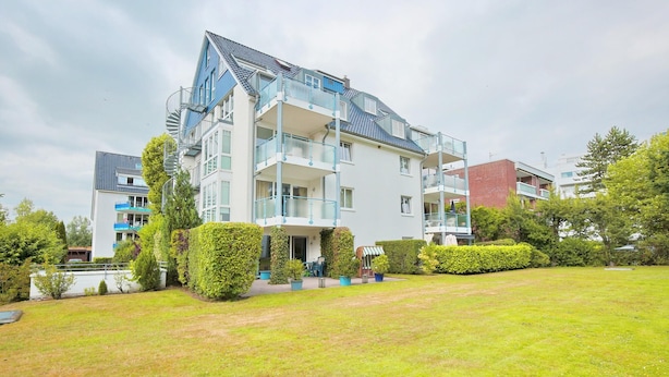 A modern multi-story residential building with balconies, a well-maintained lawn, and surrounding greenery. - Hansa-residenz I Appartement 17 Kumweer (Scharbeutz)