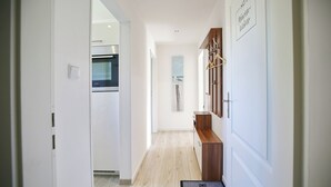 A hallway with a wooden bench, a wall-mounted coat rack, and a door labeled "No. 3". - Ferienhaus Brandt Appartement 3 Möwenkieker (Haffkrug)