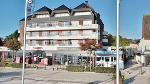 A multi-story building with a restaurant named "Janny's" on the ground floor. - Strandperle Appartement 203 (Haffkrug)