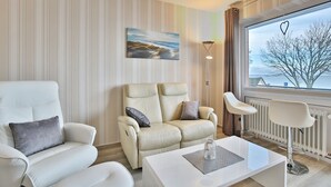 Een moderne woonkamer met een bank, fauteuil en salontafel.