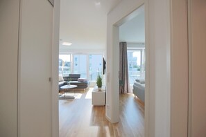 A modern apartment with a living room, dining area, and balcony. - Villa Seeperle I Appartement 5 (Scharbeutz)