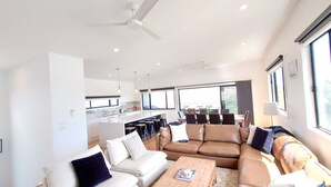 Una sala de estar moderna con sofá, mesa de centro y comedor con sillas y mesa.