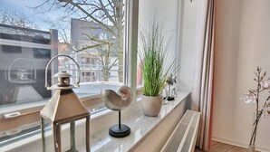 A window sill with a decorative lantern, a potted plant, and a radiator. - Barke Appartement 202 (Scharbeutz)