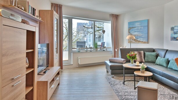 A modern living room with a sofa, coffee table, and TV stand. - Barke Appartement 202 (Scharbeutz)