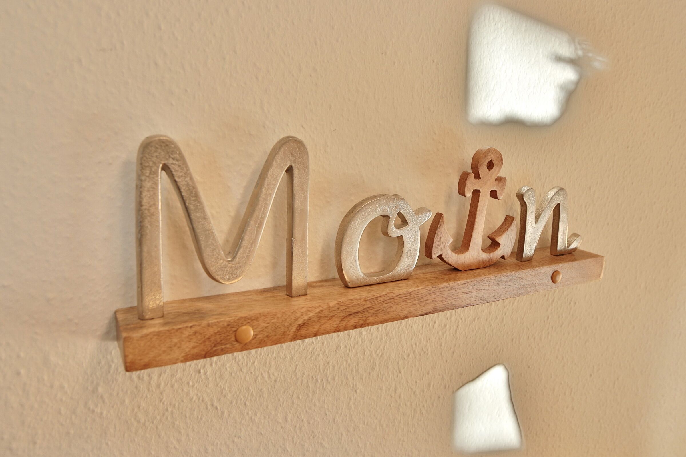 Een houten plank met de naam 'Marina' in grote letters.