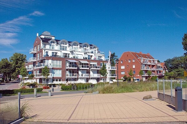 A modern apartment building with multiple balconies and a spacious outdoor area.
