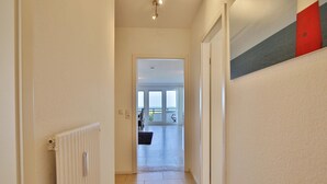A hallway leading to a room with a view of the outdoors. - Residenz am Hang Appartement 103 (Scharbeutz)