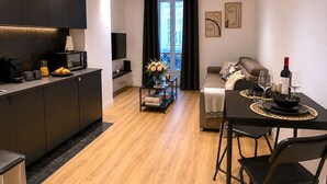 A modern apartment with a kitchen, dining area, and living room.