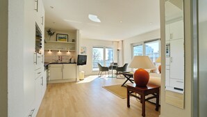 A modern apartment with a kitchen, dining area, and living room. - Barke Appartement 324 (Scharbeutz)