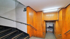A staircase with wooden walls and metal handrails, leading to a room with a motorcycle. - Rio Spot Homes C039 (Rio de Janeiro)