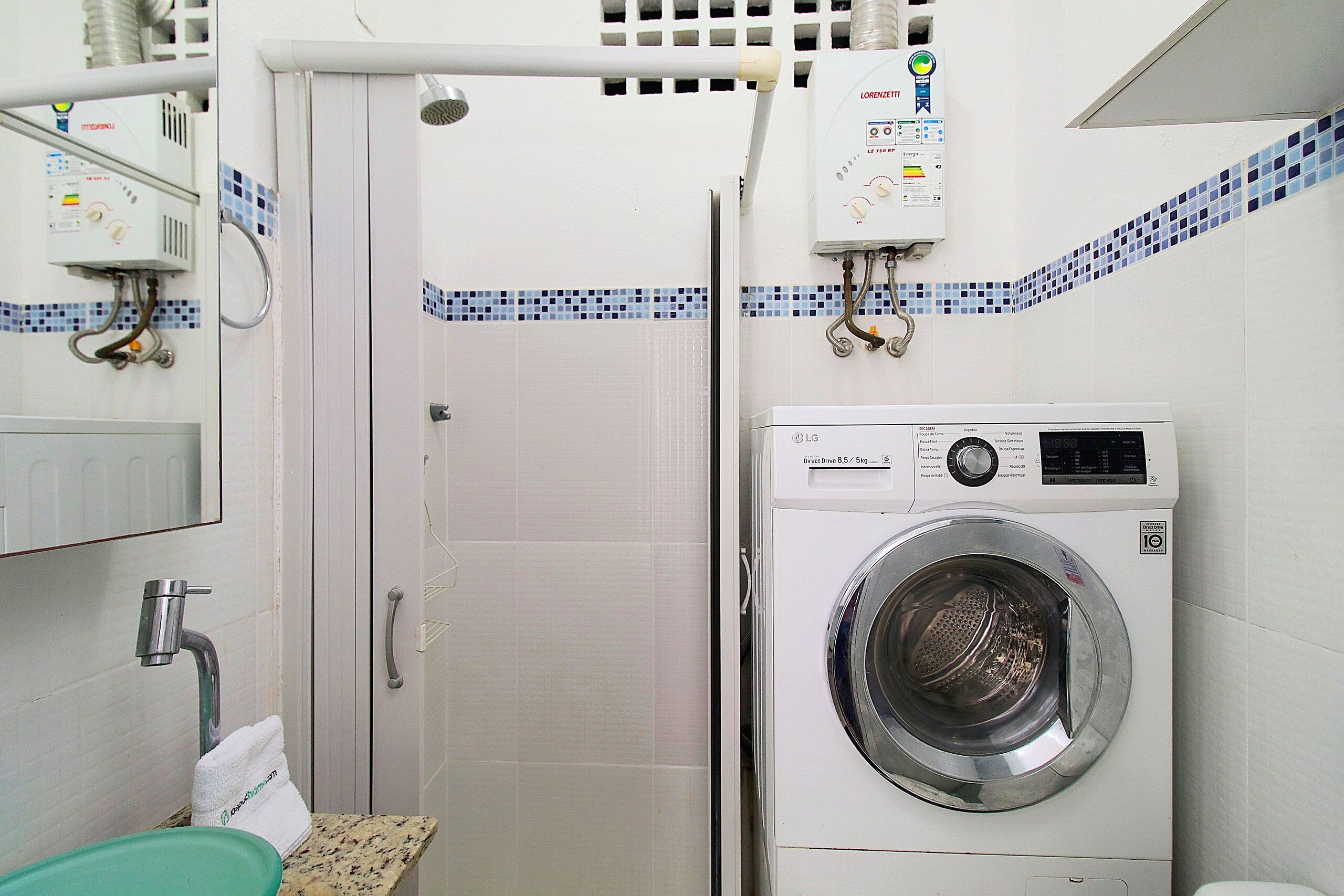 A laundry room with a washing machine, a water heater, and a towel rack.