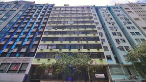 A multi-story building with a modern architectural design, featuring numerous windows and air conditioning units. - Rio Spot Homes C039 (Rio de Janeiro)