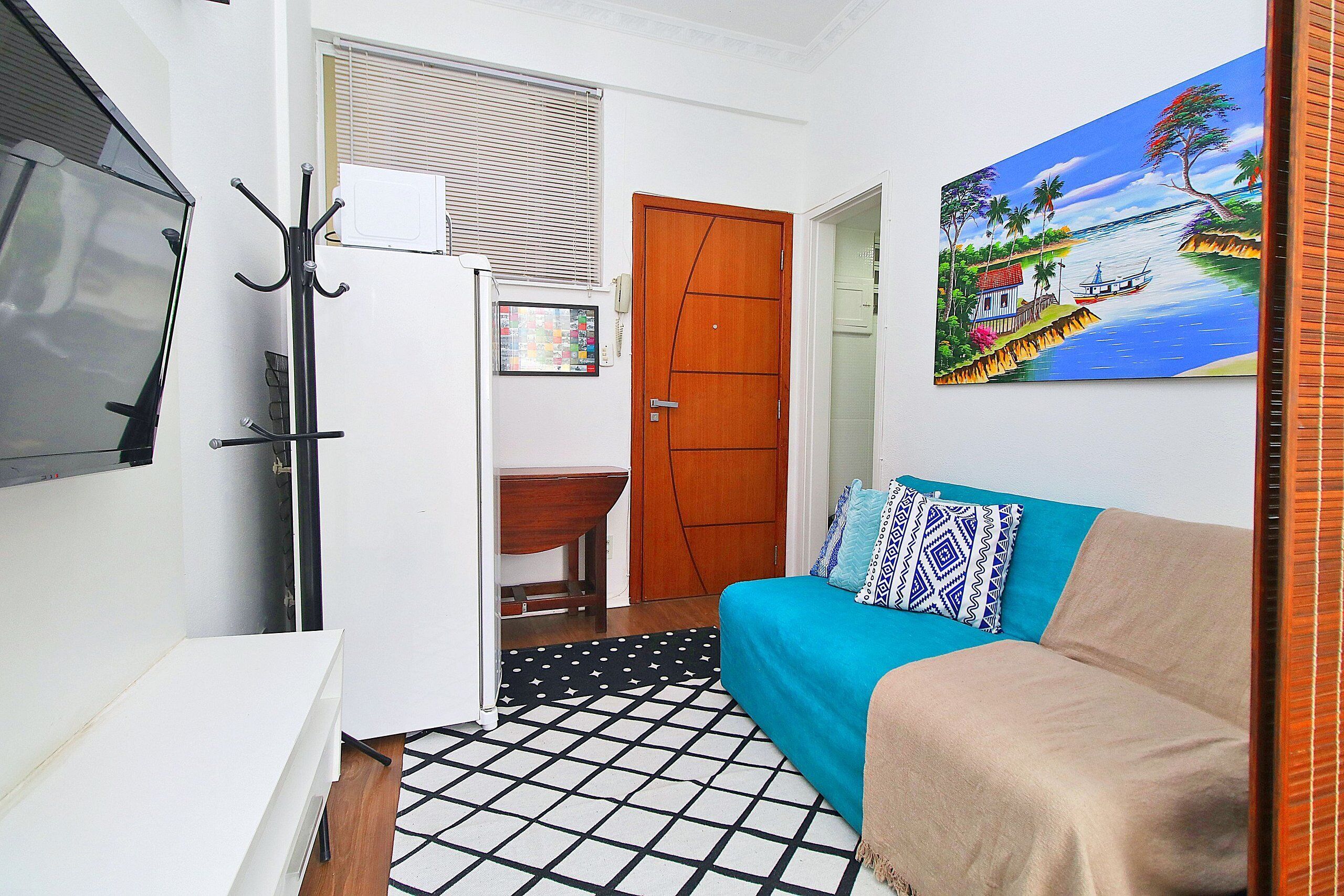 Une petite chambre comprenant un lit, un bureau et un téléviseur.
