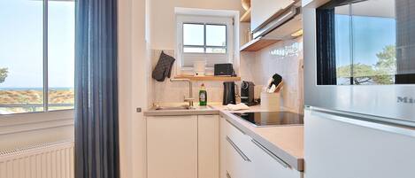 Eine moderne Küche mit Fenster, Backofen und Kühlschrank.