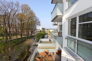 A modern building with a balcony featuring outdoor seating. - Bonheur de Plage Apartment 13A (Scharbeutz)