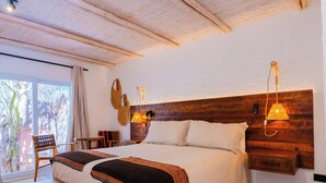 Un dormitorio espacioso con una cama grande, cabecero de madera y un banco.