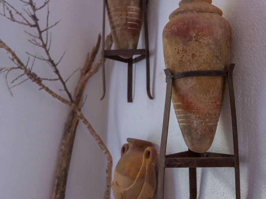 Three ceramic vases mounted on a wall with metal stands.