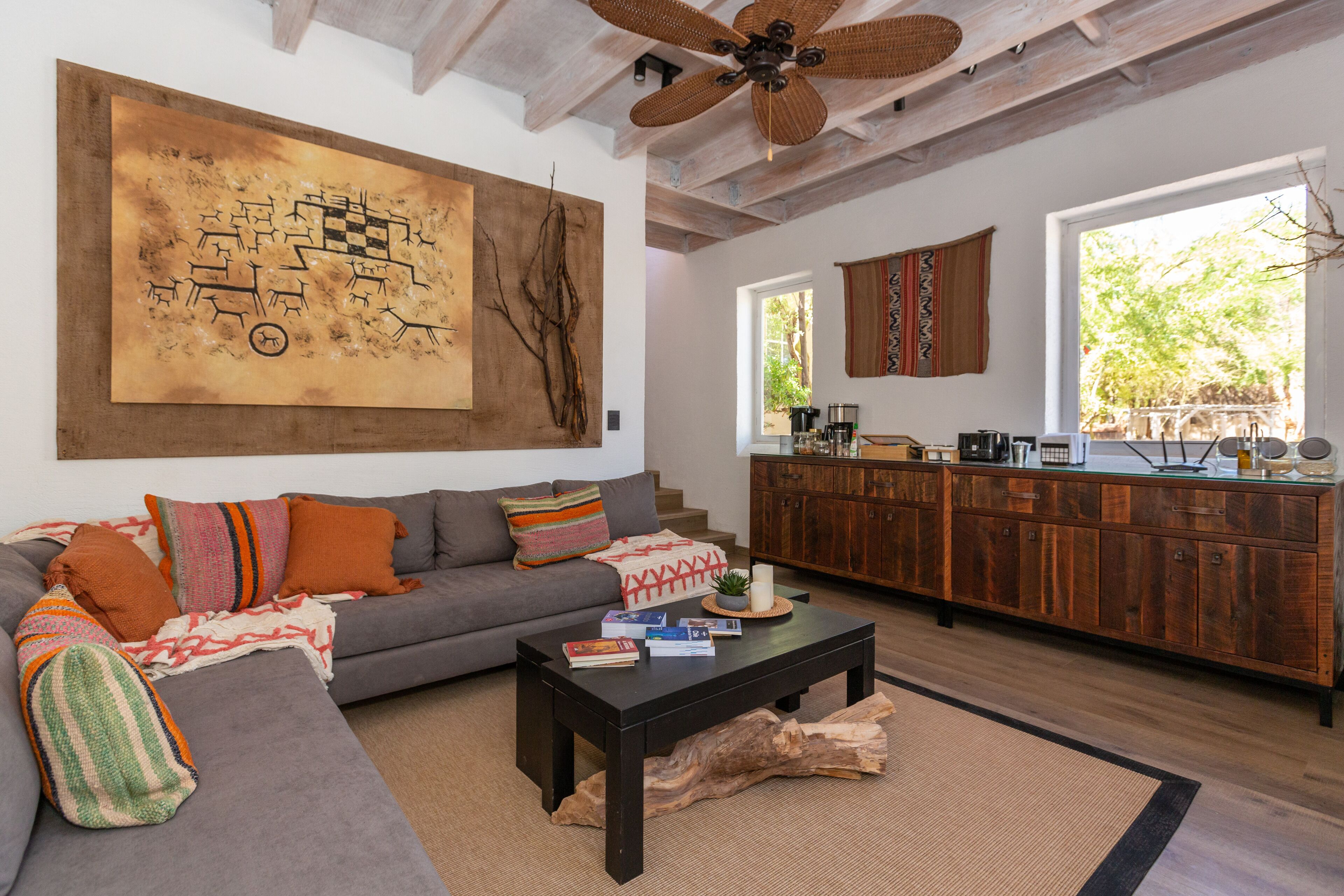 Ein Wohnzimmer mit grauem Sofa, einem Couchtisch und einem großen abstrakten Gemälde an der Wand.