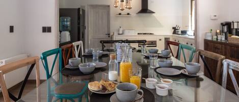 A dining table set with breakfast items, including a glass of orange juice, a cup of coffee, and plates with food.