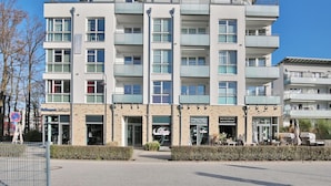 Un hôtel à plusieurs étages au design moderne, doté de balcons à chaque niveau, d’un restaurant au rez-de-chaussée et d’une enseigne bien visible indiquant l’emplacement d’un établissement situé à proximité.