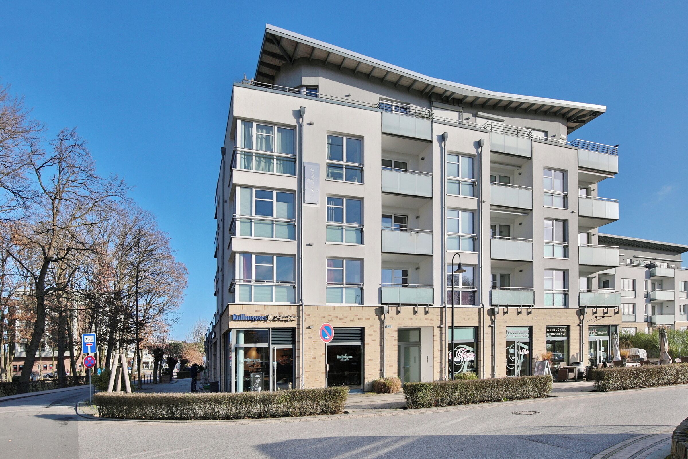 Un edificio a più piani con un design architettonico moderno, caratterizzato da balconi e ampie finestre.