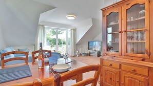 A dining area with a wooden table, chairs, and a cabinet with glass doors.