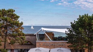 Um restaurante costeiro chamado 'FISCHKÖPPE' com área externa e vista para o mar.