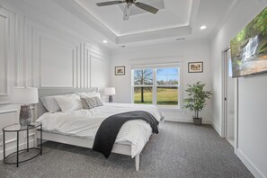 A bedroom with a bed, a window with a view, a ceiling fan, and a potted plant. - Indiana Crossing: Modern & Upscale, Near Derby (Jeffersonville)