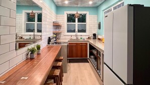 A modern kitchen with white cabinets, a wooden countertop, and a built-in oven.