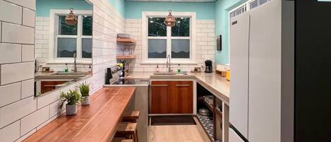 A modern kitchen with white cabinets, a wooden countertop, and a built-in oven.