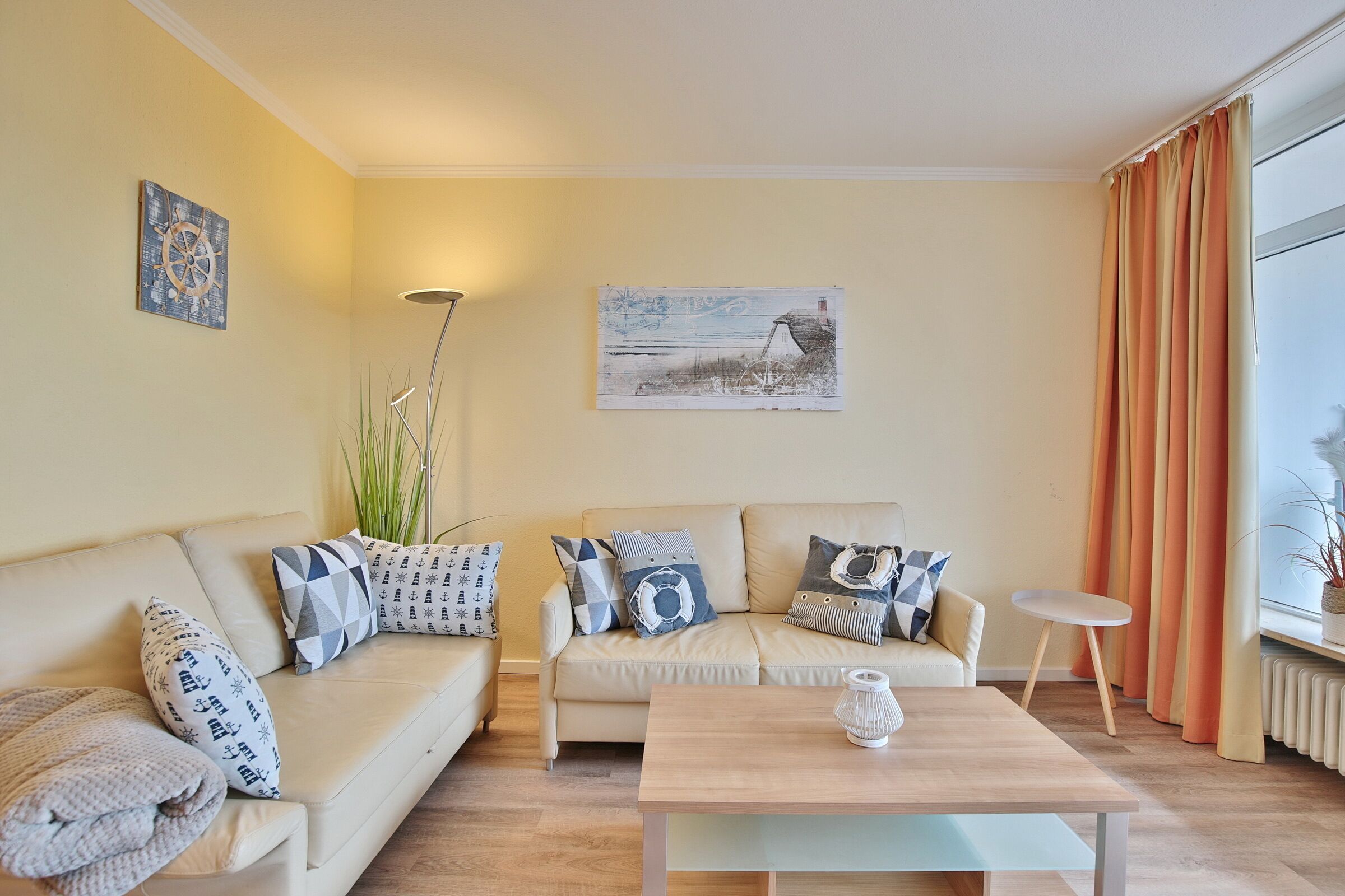 A living room with a beige sofa, a wooden coffee table, and a painting on the wall.