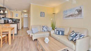 Un salon moderne avec un canapé, une table basse et un coin repas.