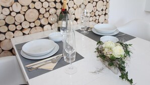Une table mise pour un repas, avec de l’argenterie blanche, des verres à vin transparents et un centre de table floral.