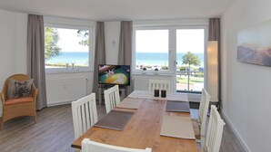 Un comedor con vistas al mar, un televisor y una silla.
