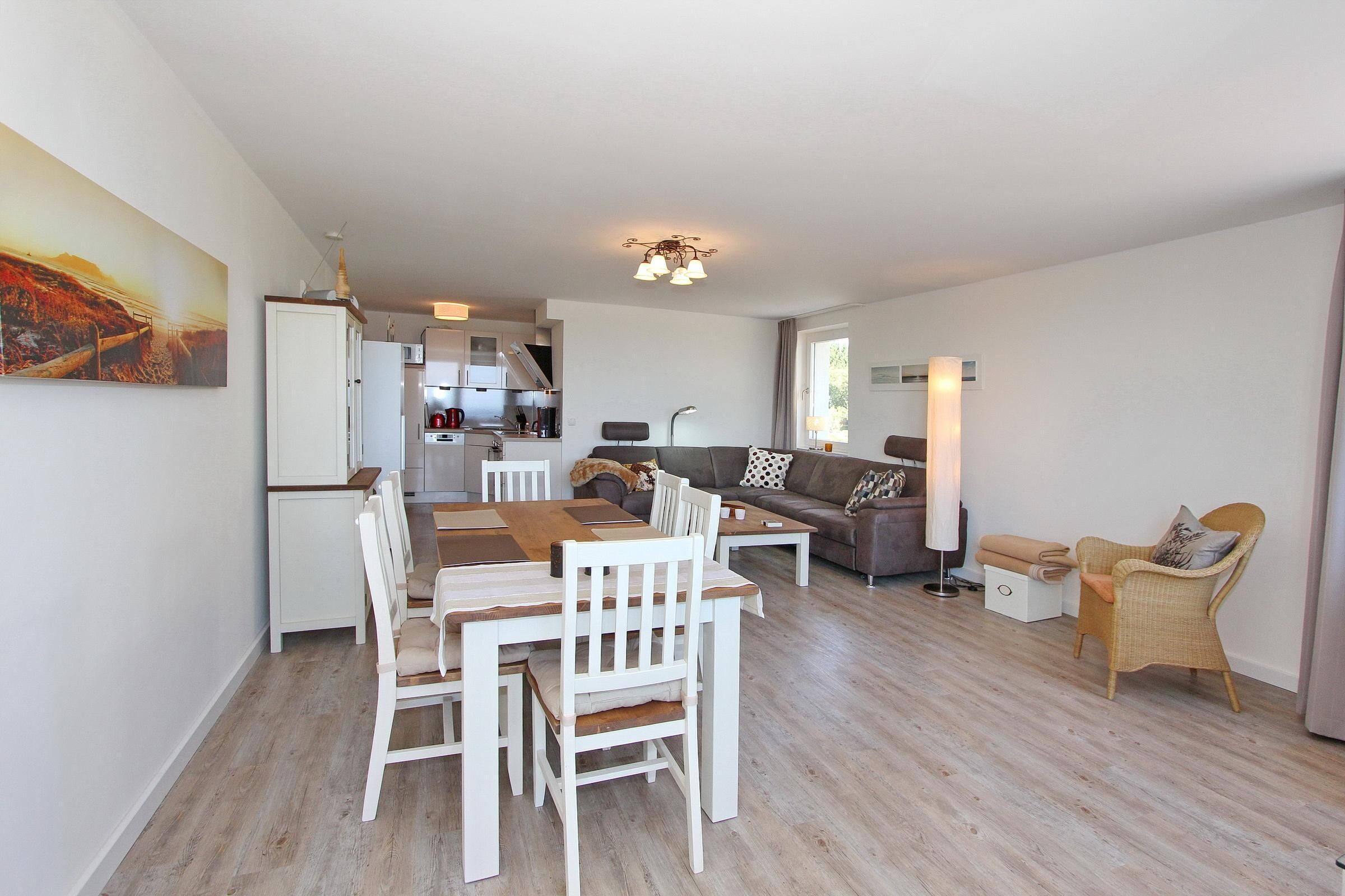 A modern living room with a dining area, a kitchen, and a sofa set.
