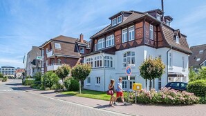 A two-story residential building with a white facade and brown roof tiles. - Villa Schöneck Appartement 1 (Scharbeutz)