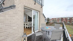 A balcony with a table and chairs, a lantern, and a view of a residential area. - Domizil am Möwenberg Appartement 9 (Scharbeutz)