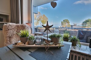 A cozy room with a view of the sea, featuring a wooden table with plants, a starfish decoration, and a rustic ambiance. - Seetempel Appartement 27 (Scharbeutz)