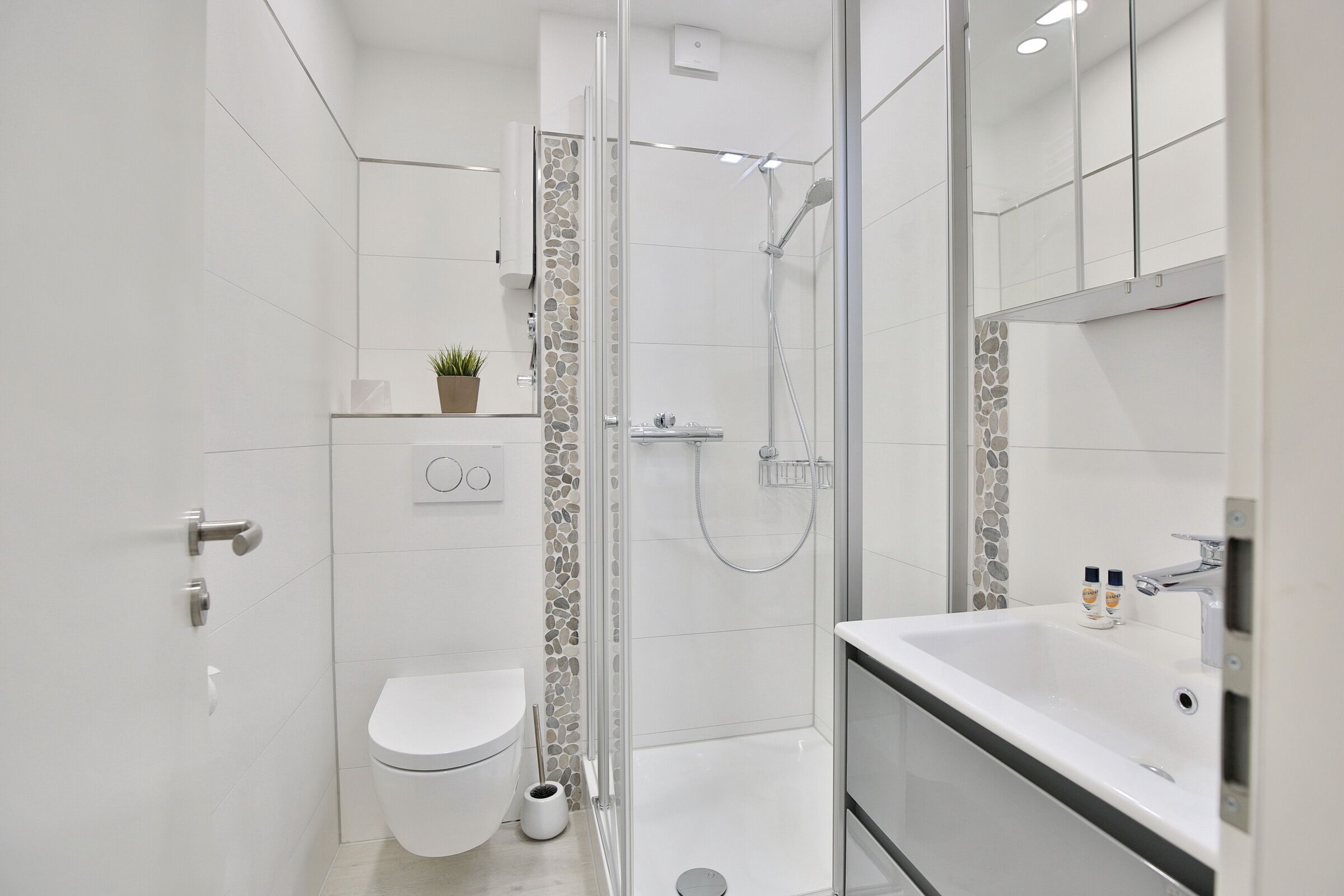Un baño moderno con inodoro, ducha y lavamanos.