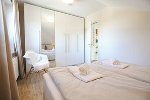 A hotel room with a bed, a chair, and a wardrobe.